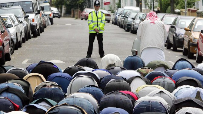 Un policía mira las plegarias de los musulmanes británicos en Londres