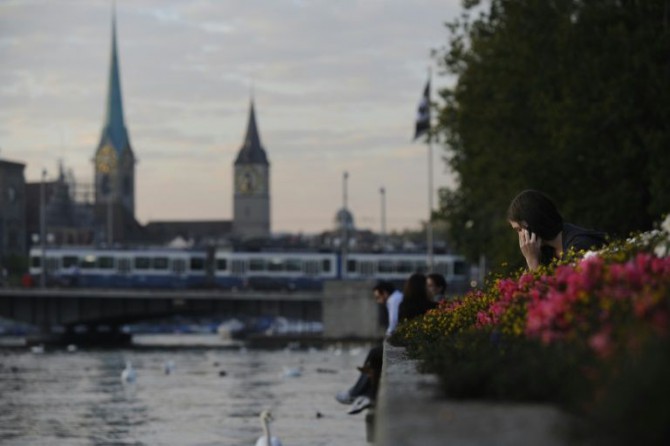 Una mujer habla por teléfono junto al lago de Zúrich