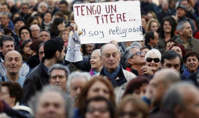 Una persona muestra un títere y un cartel alusivo durante la manifestación contra la corrupción hoy en Valencia, convocada por más de 75 entidades sociales, sindicales, políticas y ONG valencianas.