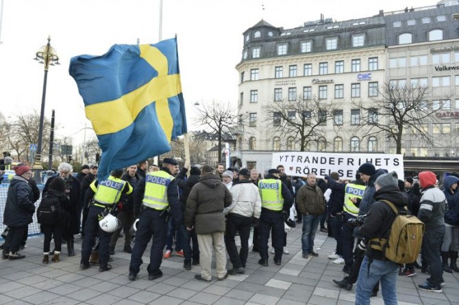 La policía de Estocolmo habla con los participantes de un movimiento autodenominado La Manifestación Popular, durante una protesta en la plaza Norrmalmstorg de la capital sueca, el 30 de enero de 2016