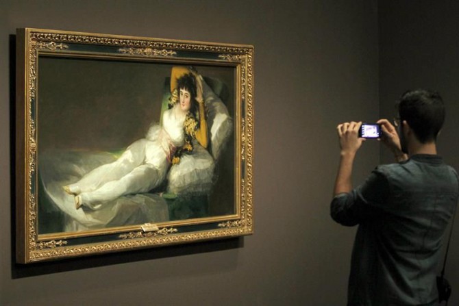 Un joven fotografía "La maja vestida" de Goya, expuesta en CaixaFórum Barcelona.
