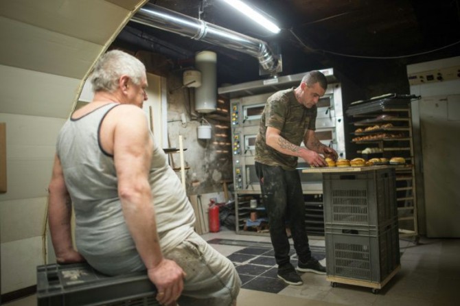Michel Flamant (izq) y Jérôme trabajando en la panadería el 23 de marzo de 2016 en Dole, Francia