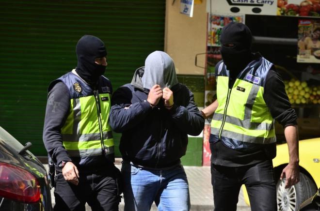 El detenido sale del domicilio acompañado por la Policía Nacional.