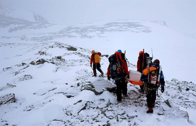 Un grupo de científicos transportan una batería a la cima del monte Rossman, Antártida.