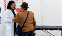 Una médico atiende a una de las personas que ha acudido hoy a la carpa que la división de Cáncer de Piel y Melanoma España, integrada en el Grupo Español de Pacientes con Cáncer (Gepac), ha instalado en la Plaza de Santa Isabel II de Madrid.