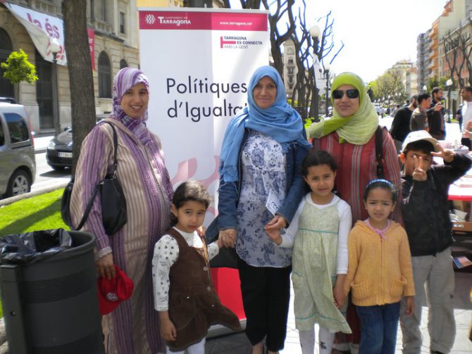 Musulmanas con sus hijos junto a un cartel del Ayuntamiento de Tarragona en favor de las "polítiques d'igualtat"