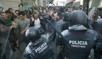 Manifestantes y antidisturbios de los Mossos d'Esquadra, durante los incidentes producidos el domingo en el barrio de Gràcia de Barcelona.