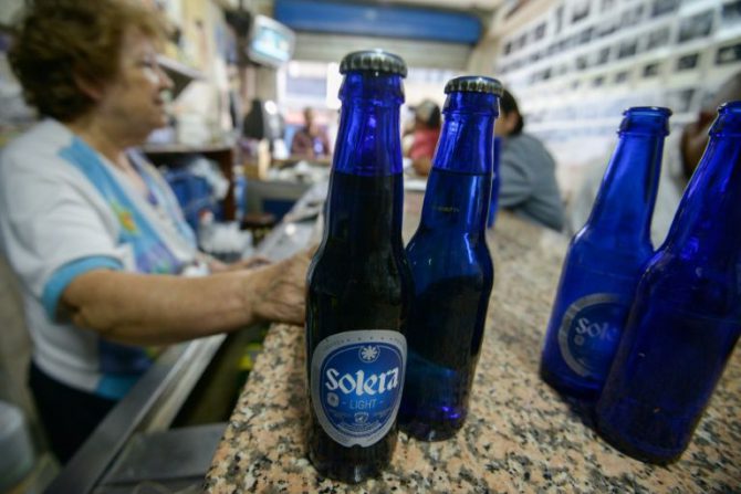 Una mujer vende cerveza Polar en un bar de Caracas.