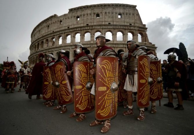 Varios hombres disfrazados de antiguos centuriones romanos, junto al Coliseo de la capital italiana.