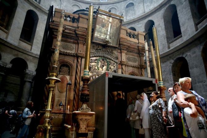 Varios turistas haciendo fila para entrar en la tumba de Jesús, con un andamio en su entrada, en la iglesia del Santo Sepulcro de Jerusalén, el 29 de mayo