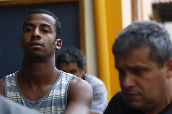 Un policía brasileño escolta a Raí de Souza (i) en Río de Janeiro (Brasil).