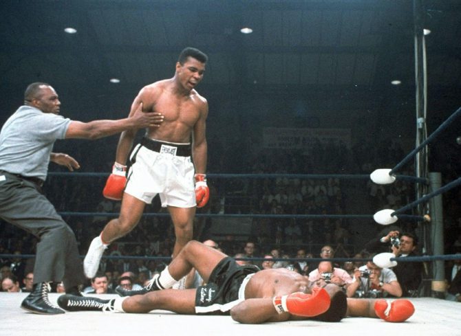 En esta imagen de archivo del 25 de mayo de 1965, el campeón de peso completo Muhammad Ali es retenido por el árbitro Joe Walcott, a la izquierda, después de que Ali noqueara a su rival Sonny Liston en el primer asalto de su combate por el título en Lewiston, Maine.