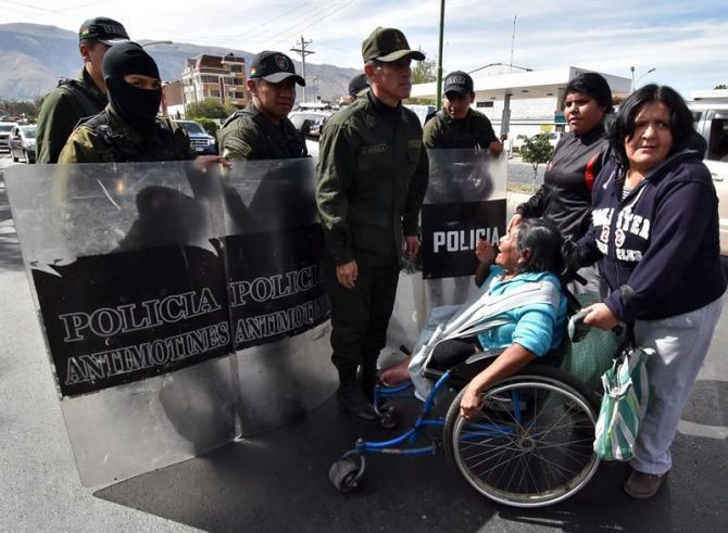 Policías Bolivianos desalojan a una docena de personas con discapacidad, en sillas de ruedas y con muletas luego de que protestaran frente a las puertas de la clínica donde operaron de una rodilla al presidente boliviano, Evo Morales, y que estuvo custodiada por decenas de policías. 