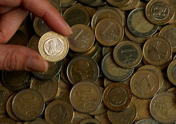 Una persona enseña una moneda de euro.