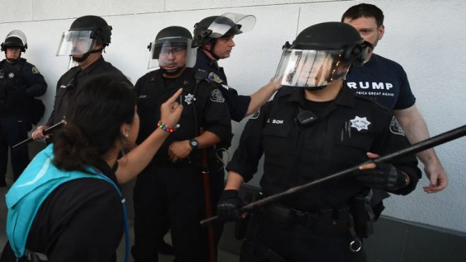 Una mujer grita a un seguidor de Trump mientras la policía los separa.