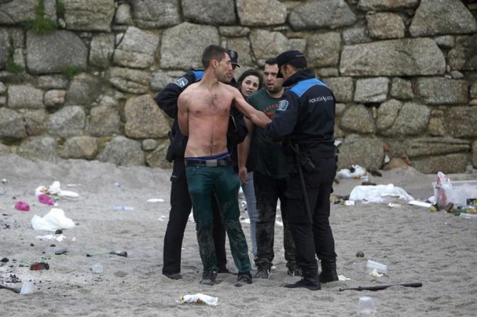Agentes de la Policía Local de A Coruña arrestan al joven que se bañaba en la playa del Orzán, la más peligrosa de la bahía coruñesa, sin hacer caso de las advertencias de la Policía Local.