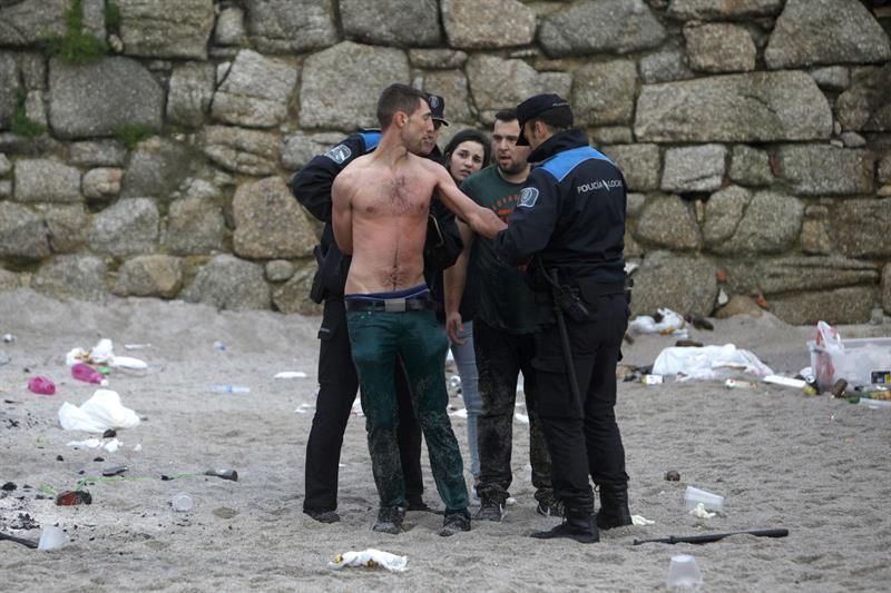 Agentes de la Policía Local de A Coruña arrestan al joven que se bañaba en la playa del Orzán, la más peligrosa de la bahía coruñesa, sin hacer caso de las advertencias de la Policía Local.