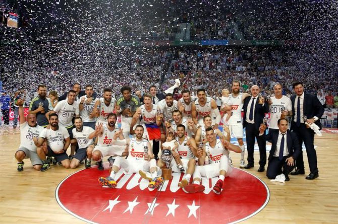 La plantilla del Real Madrid celebra con la Copa de campeones de la Liga ACB tras vencer al FC Barcelona Lassa en el cuarto partido de la final, en el Palacio de los Deportes de Madrid.