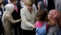 La canciller alemana Angela Merkel (c) y el primer ministro turco Ahmet Davutoglu (atrás)hablan con refugiados el 23 de abril de 2016 en Gaziantep.