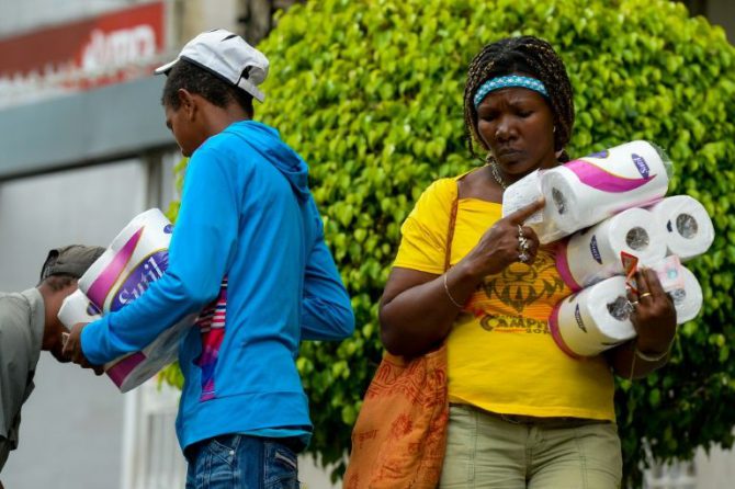 Unas personas salen de un supermercado de la barriada de Petare, en Caracas.