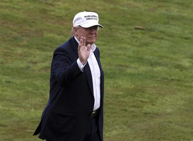 El virtual candidato republicano a la presidencia de EEUU, Donald Trump, saluda a su llegada al campo de golf de Trump Turnberry en Escocia, Reino Unido, hoy.