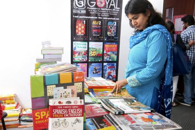 Una mujer observa varias publicaciones en castellano en las celebraciones del Día del Español en la India en el Instituto Cervantes de Nueva Delhi.