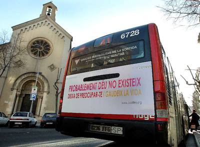 Un autobús con un letrero ateo y hedonista pasa junto a una iglesia en Barcelona.