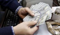 Un hombre cuenta billetes en una oficina de cambio de divisas.