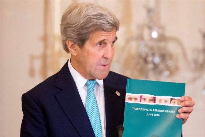 El secretario de Estado de EE.UU., John Kerry, sostiene una copia del informe anual de su Gobierno sobre el tráfico de personas en el mundo en la sala Ben Franklin del Departamento de Estado en Washington, Estados Unidos.