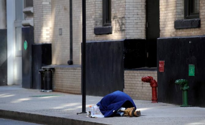 Un mendigo duerme en una calle de Nueva York, EE.UU.