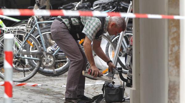 Un oficial registra los restos que quedaron en la zona del atentado