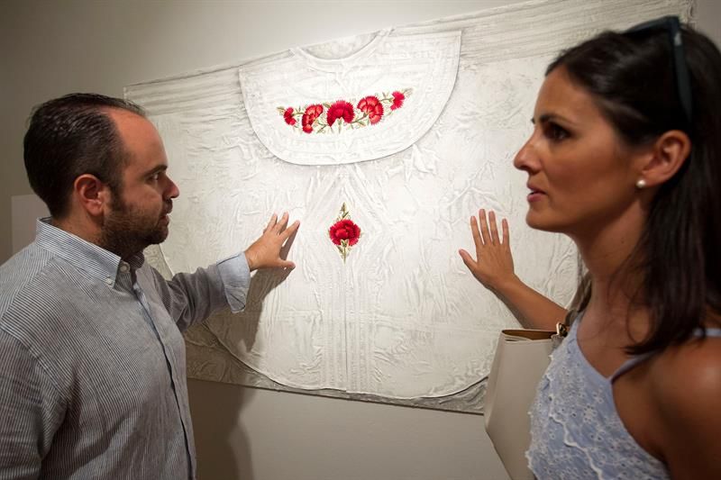 Dos visitantes tocan un panel que forma parte de la exposición "Se ruega tocar. Minotauro ciego", del artista francés Loren Pallatier, un espacio en el que invita a conocer distintas texturas del mundo del toro a través del tacto, y que se ha inaugurado hoy en el Centro Cultural María Victoria Atencia de Málaga.