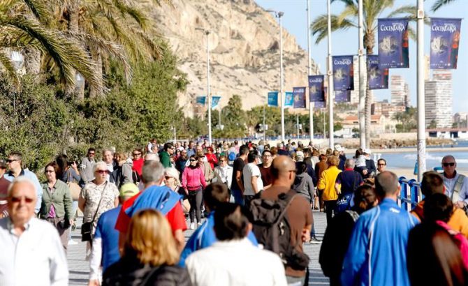 Centenares de turistas disfrutan del sol y las altas temperaturas en la playa del Postiguet, en Alicante. 