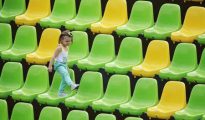 Una niña juega entre los asientos vacíos del estadio Deodoro durante el encuentro entre Colombia y Kenia de rugby olímpico femenino en Río de Janeiro