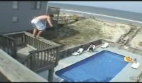 Un joven, en pleno salto a una piscina desde un balcón.