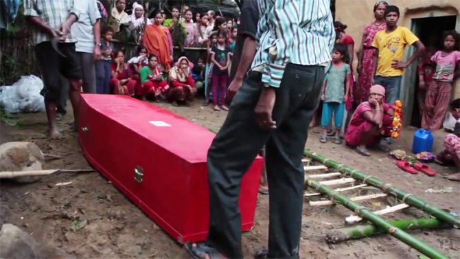 La familia de un trabajador nepalí fallecido en Qatar durante las obras de construcción de un estadio de fútbol se prepara para enterrarlo. En Qatar, los trabajadores extranjeros trabajan en condiciones muy peligrosas; sólo los nepalíes mueren a un ritmo de uno cada dos días. (Imagen: captura de un vídeo del 'Guardian').