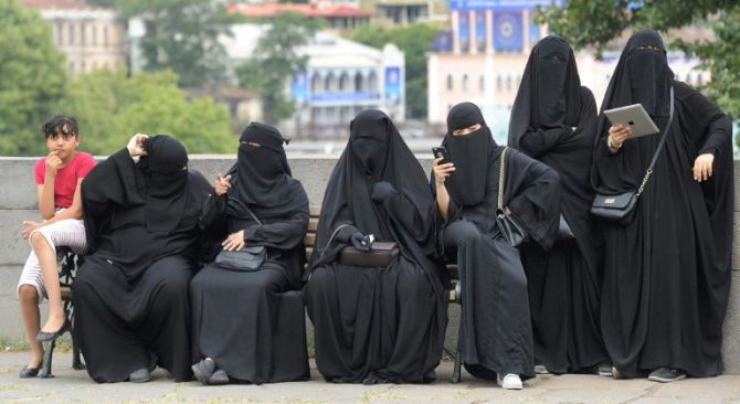 Turistas vestidas con velo islámico integral descansan el 16 de agosto de 2016 en un banco en el centro de Tiflis, Georgia