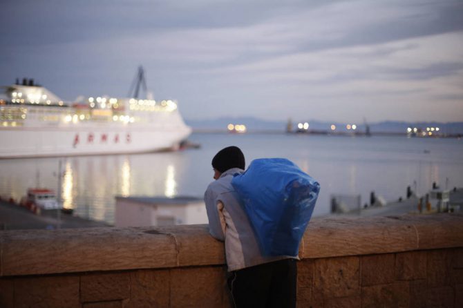 Un joven marroquí observa un barco a punto de partir del puerto de Melilla. 