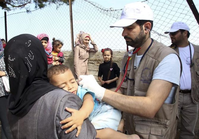 Voluntarios de la Organización No Gubernamental 'Doctores de Chipre' atienden a un niño en el campo de refugiados instalado en la isla de Chios, Grecia.