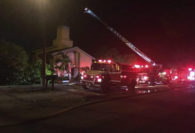 Fotografía facilitada por el Departamento Policial del Condado de Santa Lucía, que muestra a varios bomberos y policías en su intento de controlar las llamas en el Centro Islámico Fort Pierce de Florida, Estados Unidos. 