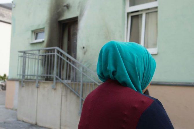 Una mujer cubierta con un pañuelo permanece frente a la entrada de la mezquita Fatih Camii en Dresde, al este de Alemania