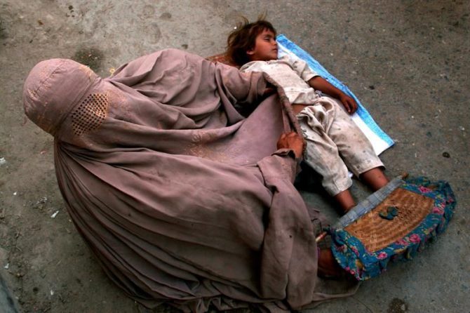 Una mujer con burka y su hija piden limosna en una calle de Peshawar (Pakistán).