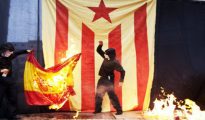 Dos miembros de la CUP quemando imágenes del Rey y banderas de España.