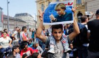 Amores que matan: Un refugiado sirio exhibe una fotografía de Angela Merkel.