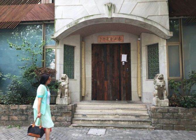 Una mujer pasa por delante del cerrado restaurante Taian Table de Shanghai 