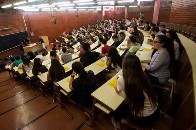 Unos estudiantes atienden a las instrucciones en una Facultad.