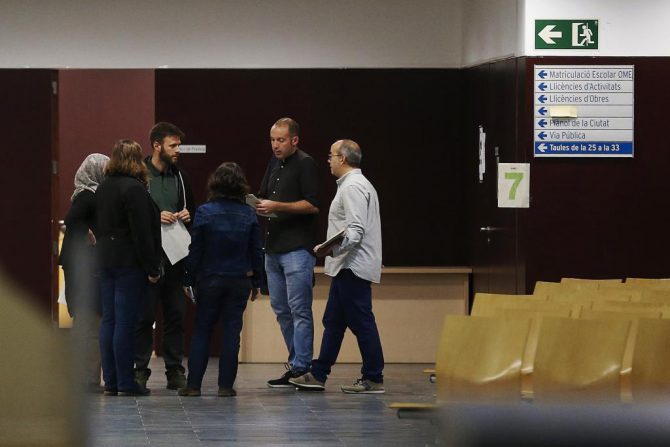 Los concejales del Ayuntamiento de Badalona atienden a los ciudadanos en el interior del recinto, tras desobedecer la resolución de un juzgado barcelonés contra su voluntad de abrir las dependencias municipales en el Día de la Hispanidad.