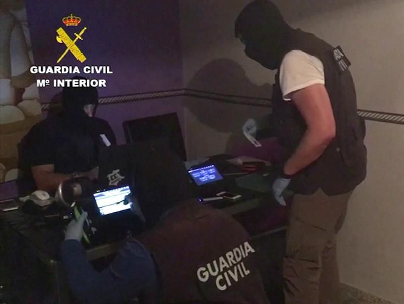 Imagen de vídeo facilitada por la Guardia Civil, de tres agentes de la Benemérita analizando los dispositivos electrónicos que han inautado hoy a dos imanes marroquíes, que han sido detenidos hoy en Ibiza por su presunto apoyo al grupo terrorista Estado Islámico (EI).