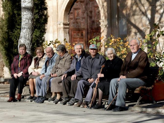 Varios ancianos toman el sol.