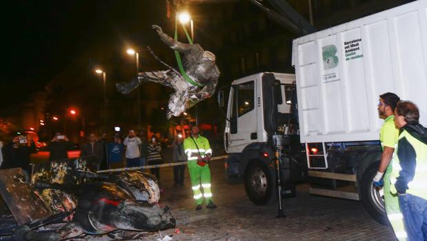 Momento en el que los operarios municipales retiran la estatua de Franco derribada 